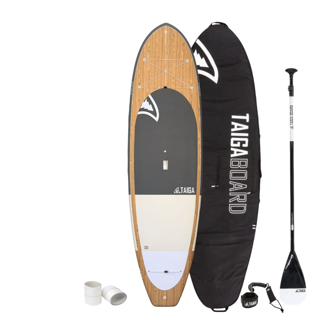 Paddleboard with wooden finish, black cover, paddle, and accessories on a white background
