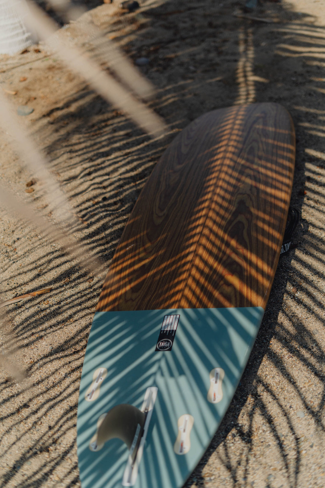 Back of the TAIGA Malibu 7'2" surfboard on the beach