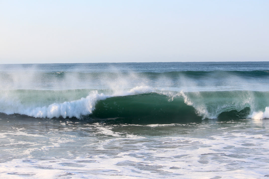 Wave crashing in the ocean with a clear sky