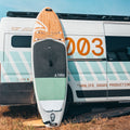 Front View of The Akoya Air 9'6" Leaning on a VAN