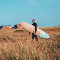 Guy Holding The Malibu Surf Board 7'2" in a Field