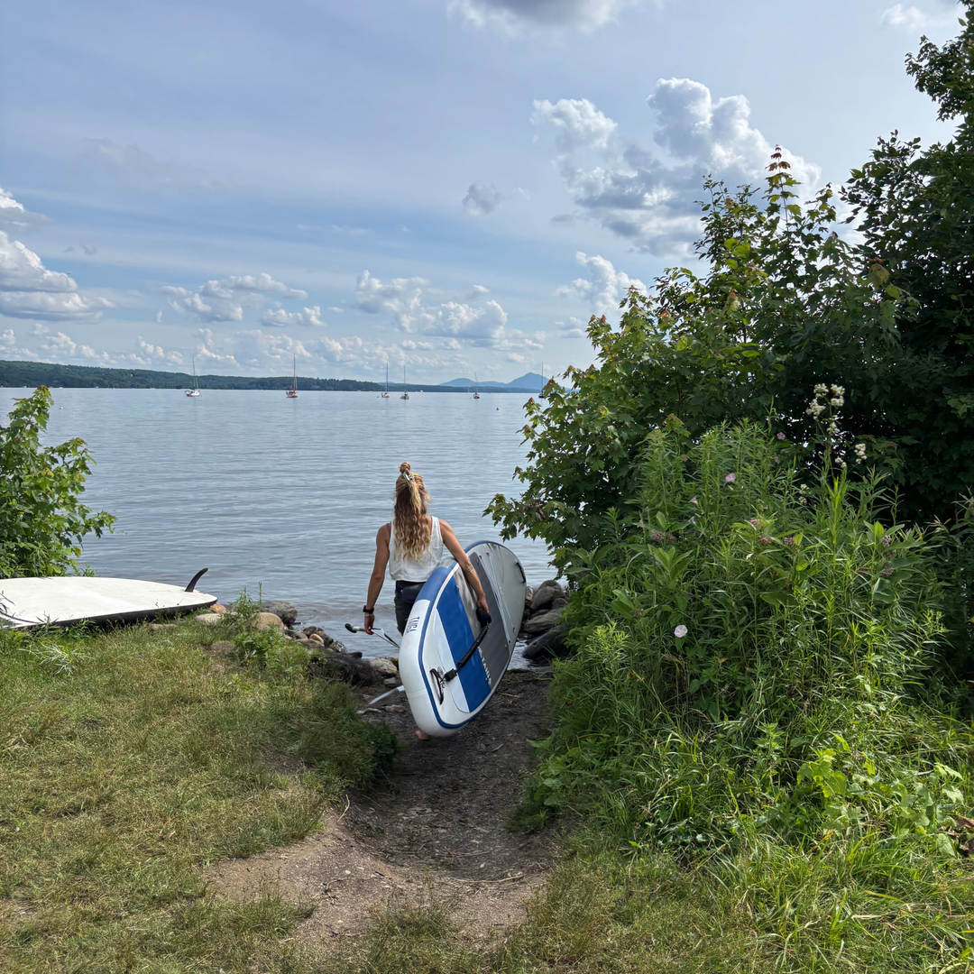Back View of a Paddler Transporting The Ukee Air 10'8" to The Beach