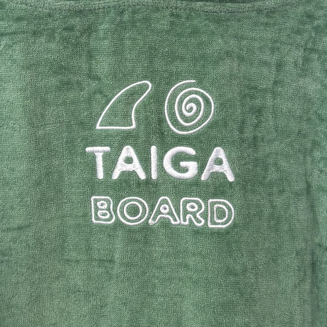 Green towel with 'TAIGA BOARD' text and logo on a green background