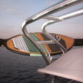 A close-up of a wakesurf resting on the deck of a boat, with water and shoreline visible in the background. 