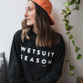 Woman wearing the BLACK WETSUIT SEASON Crewneck by TAIGA BOARD